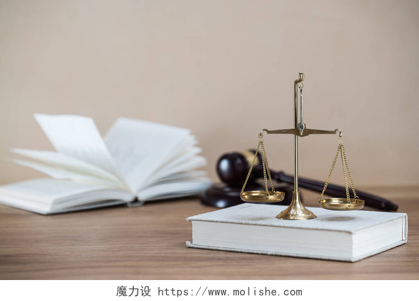 桌子上的法律书籍天平木制桌子背景上的法律和司法象征